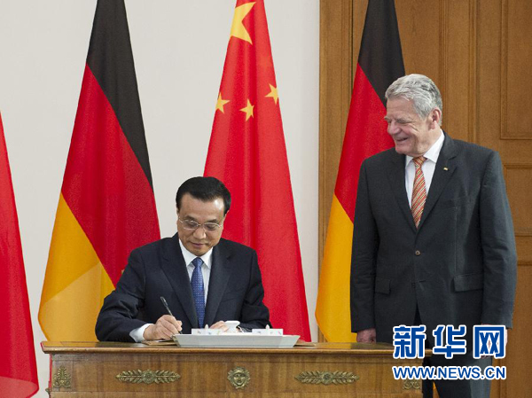 10月10日，國務院總理李克強在柏林會見德國總統高克。這是李克強總理在高克總統的陪同下在貴賓簿上簽字。 新華社記者 王曄 攝 